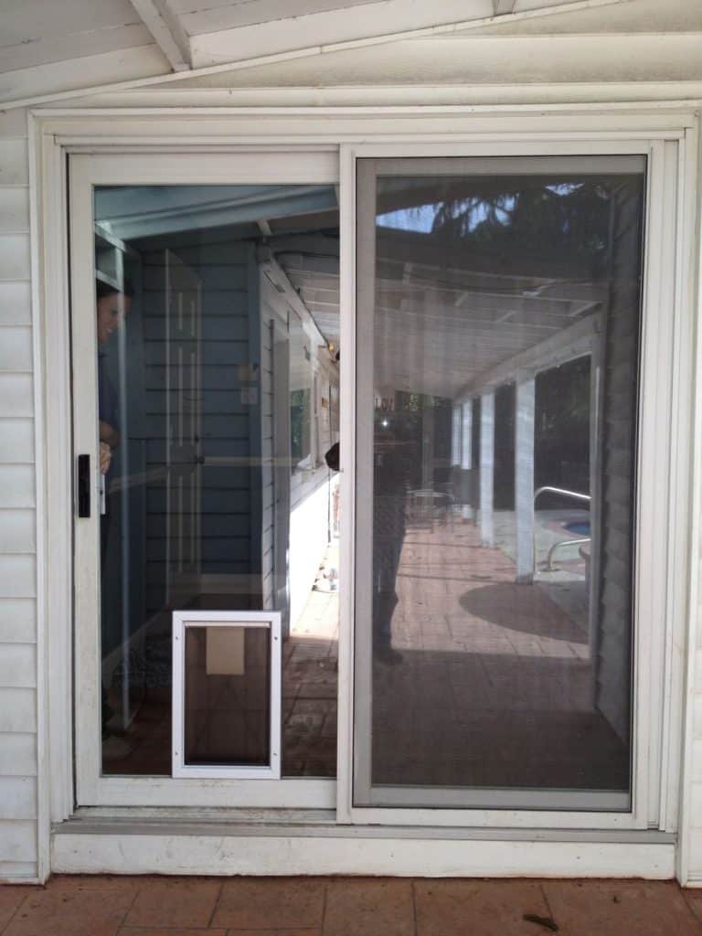 Pet door installed in rolling panel of sliding glass door